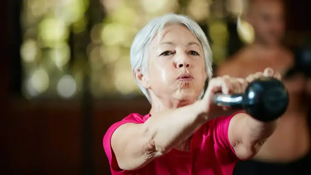 Older woman doing weight training Cumbernauld  to help her strength and longevity 