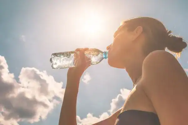 Hydration: The Secret Ingredient for a Toned Stomach and Enhanced Fitness 3 Image of woman drinking water to hydrate Cumbernauld after run.
